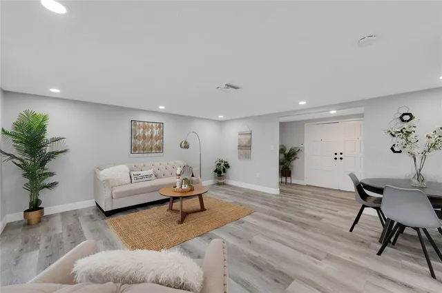 a living room with furniture and a wooden floor