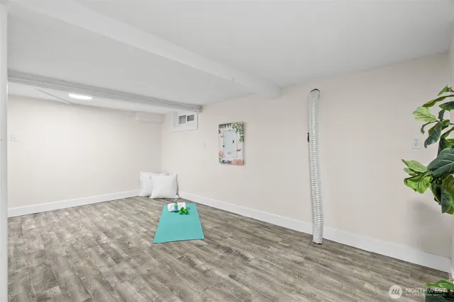 a room with a wooden floor and a potted plant