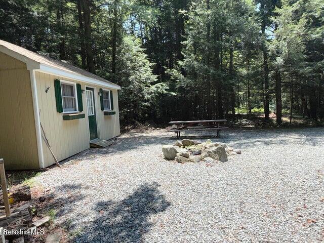759 East North Main Road, Unit V8J Otis, MA 01253 - Photo 7 of 27 a view of a backyard with table and chairs and a fire pit