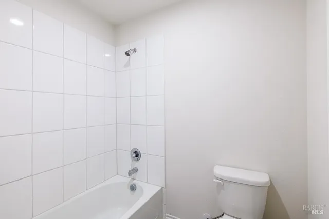 a white bath tub sitting next to a white toilet