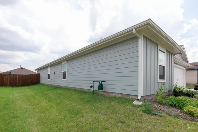 a backyard of a house with table and chairs