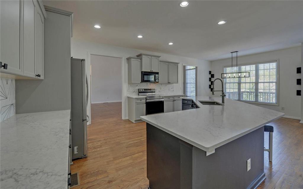 4286 Cami Way Northeast Buford, GA 30519 - Photo 11 of 39 a kitchen with kitchen island a sink stove and refrigerator