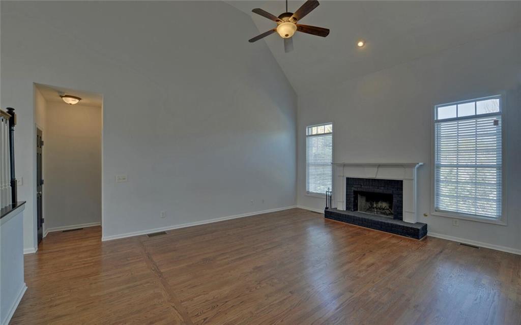 4286 Cami Way Northeast Buford, GA 30519 - Photo 15 of 39 an empty room with wooden floor fireplace and windows