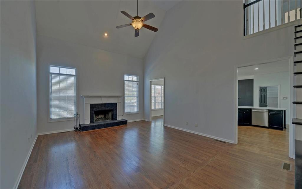 4286 Cami Way Northeast Buford, GA 30519 - Photo 16 of 39 a view of a livingroom with a fireplace a ceiling fan and wooden floor