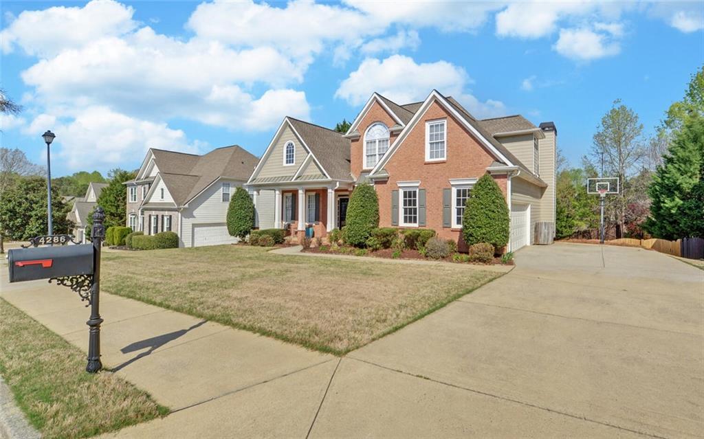 4286 Cami Way Northeast Buford, GA 30519 - Photo 2 of 39 a front view of a house with a yard and trees