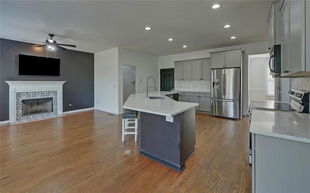 4286 Cami Way Northeast Buford, GA 30519 - Photo 7 of 39 a kitchen with stainless steel appliances a stove top oven a refrigerator and a fireplace