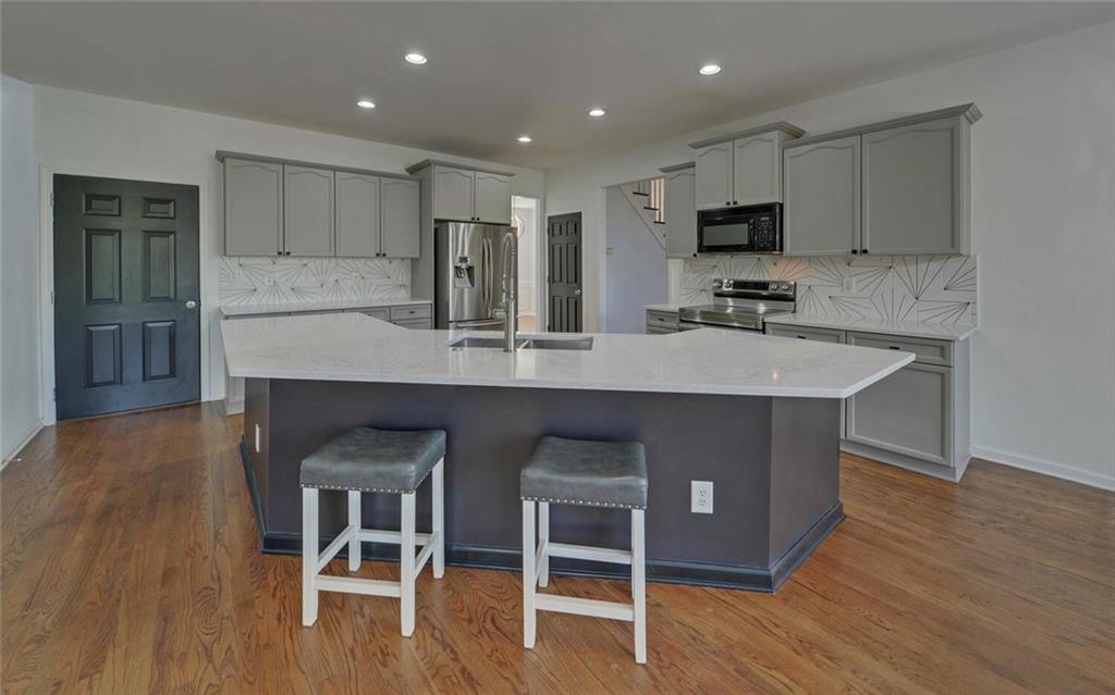 4286 Cami Way Northeast Buford, GA 30519 - Photo 10 of 39 a large kitchen with kitchen island a sink table and chairs