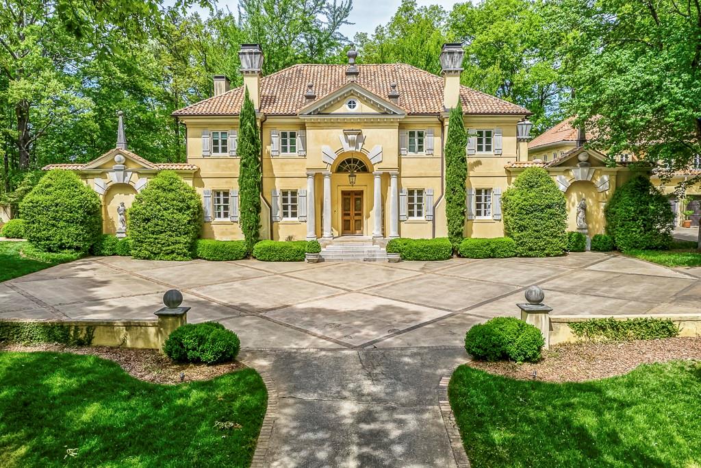 a front view of a house with a yard and potted plants