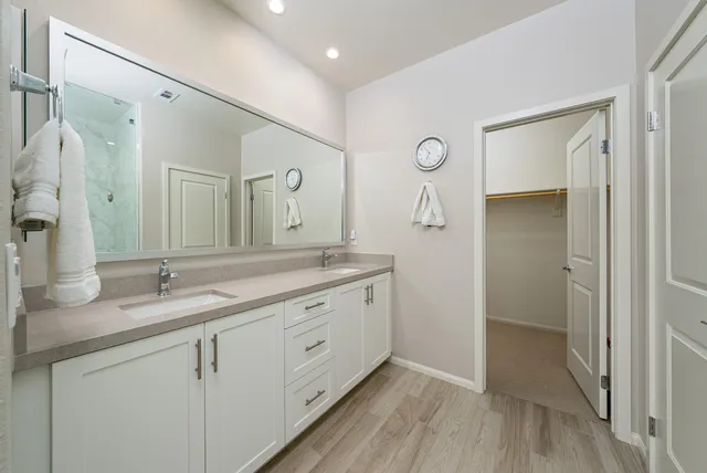 a bathroom with a granite countertop sink a mirror and a shower