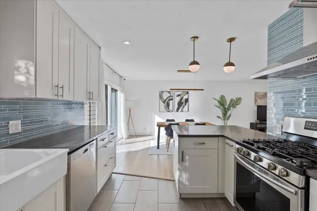 a kitchen with stainless steel appliances granite countertop a sink stove and cabinets