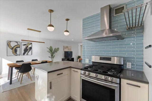 a kitchen with a stove and a wooden floor
