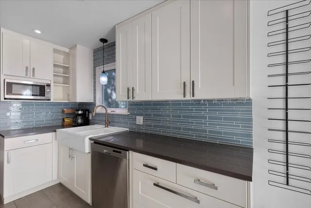 a kitchen with granite countertop white cabinets and white appliances