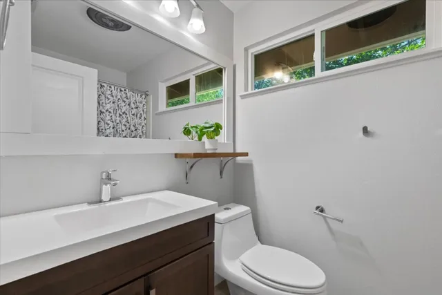 a bathroom with a toilet a sink and mirror