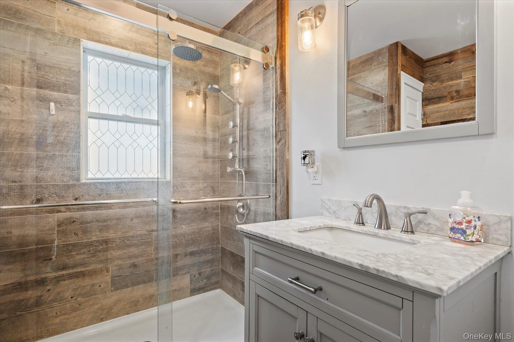 280 Moriches Road St. James, NY 11780 - Photo 11 of 39 a bathroom with a granite countertop sink a mirror and a shower