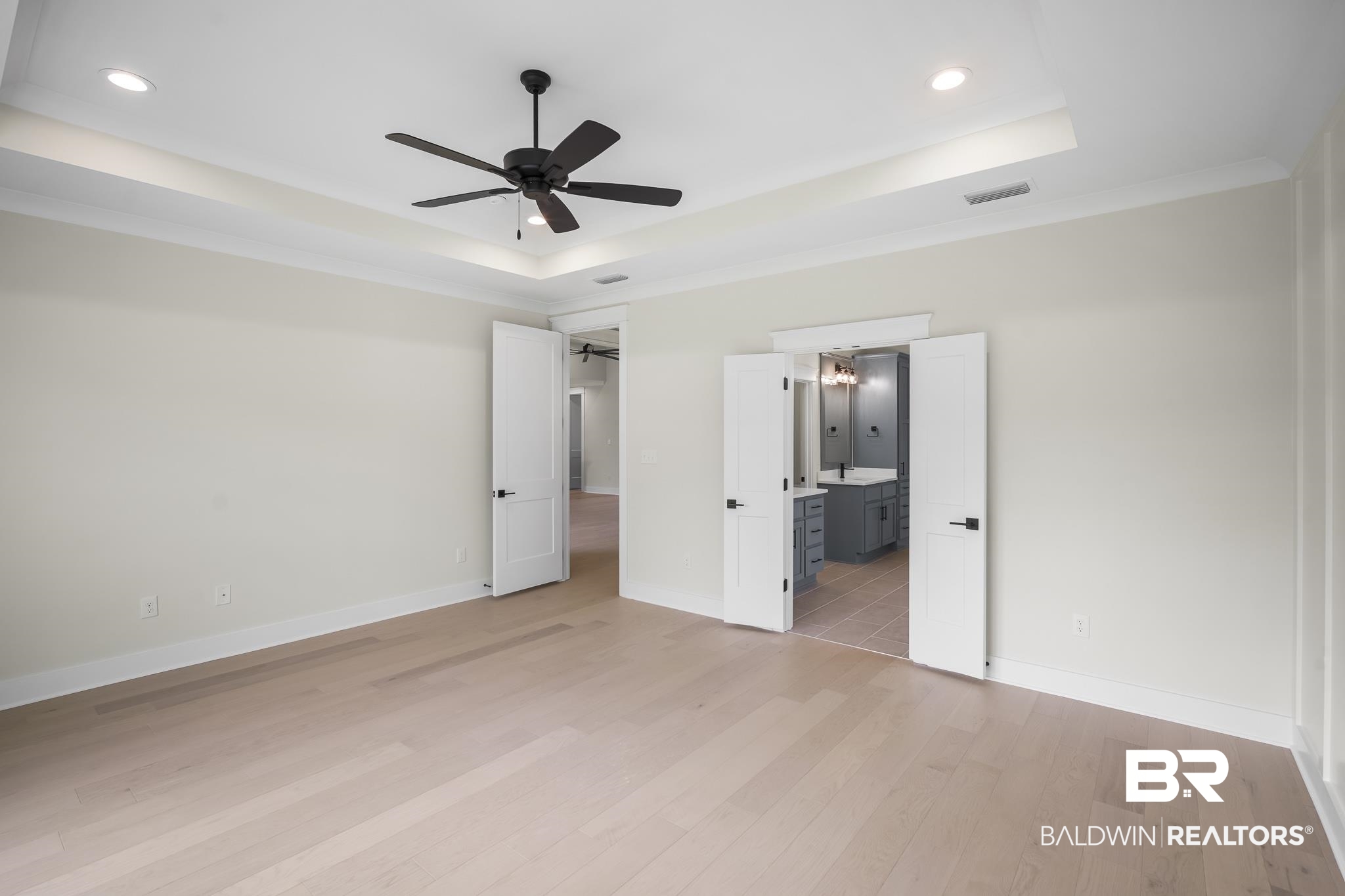 21826 Veranda Boulevard Fairhope, AL 36532 - Photo 16 of 42 Unfurnished bedroom featuring a raised ceiling, light wood-style flooring, a ceiling fan, connected bathroom, and recessed lighting
