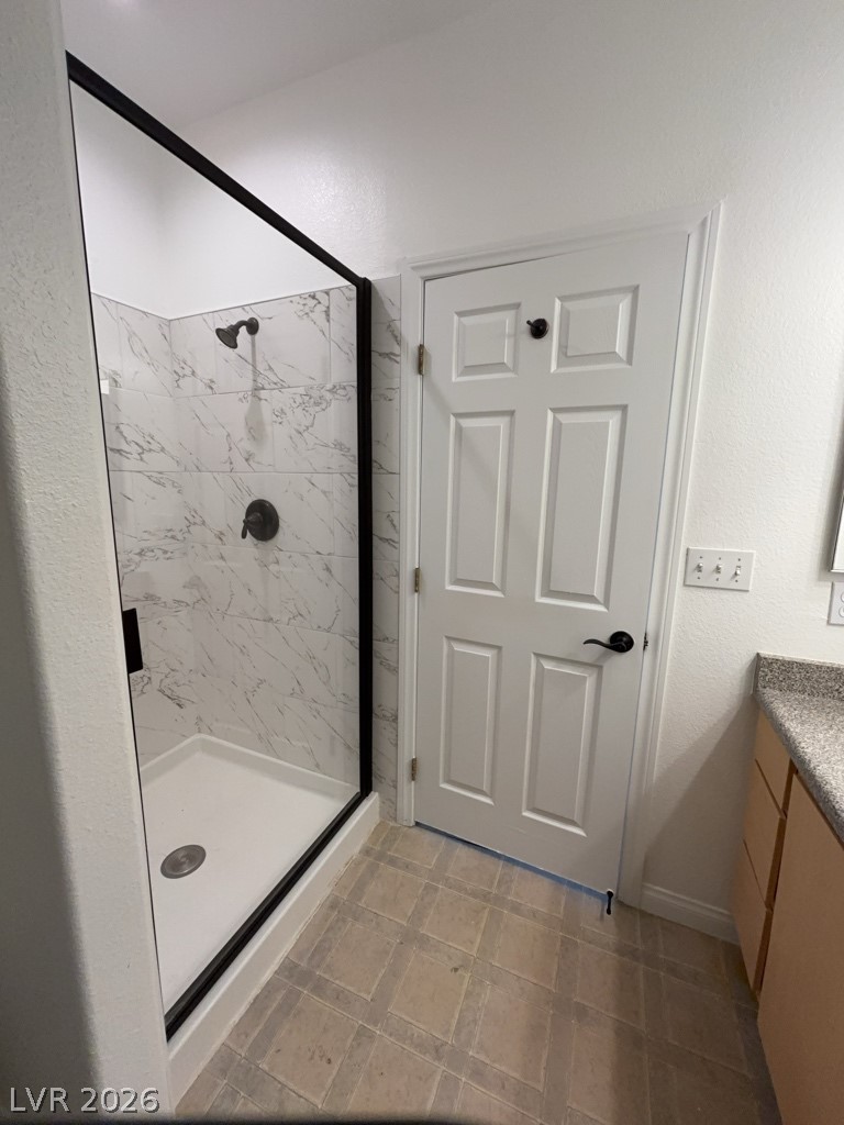4915 East Russell Road, Unit 133 Las Vegas, NV 89120 - Photo 9 of 10 A well-appointed bathroom features a glass-enclosed shower with stylish marble-patterned tiling.
