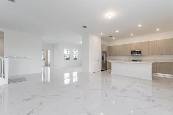 a large white kitchen with a refrigerator and white cabinets