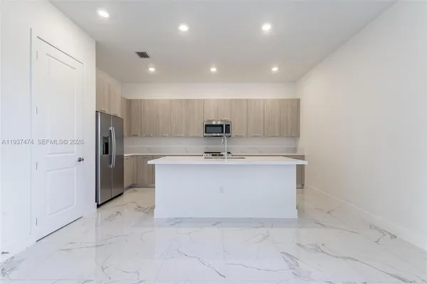 a large white kitchen with a sink