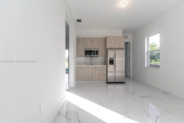 a view of a kitchen with a refrigerator a sink and dishwasher