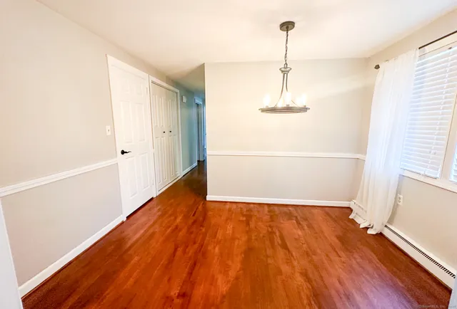 a view of a room with wooden floor and an entryway