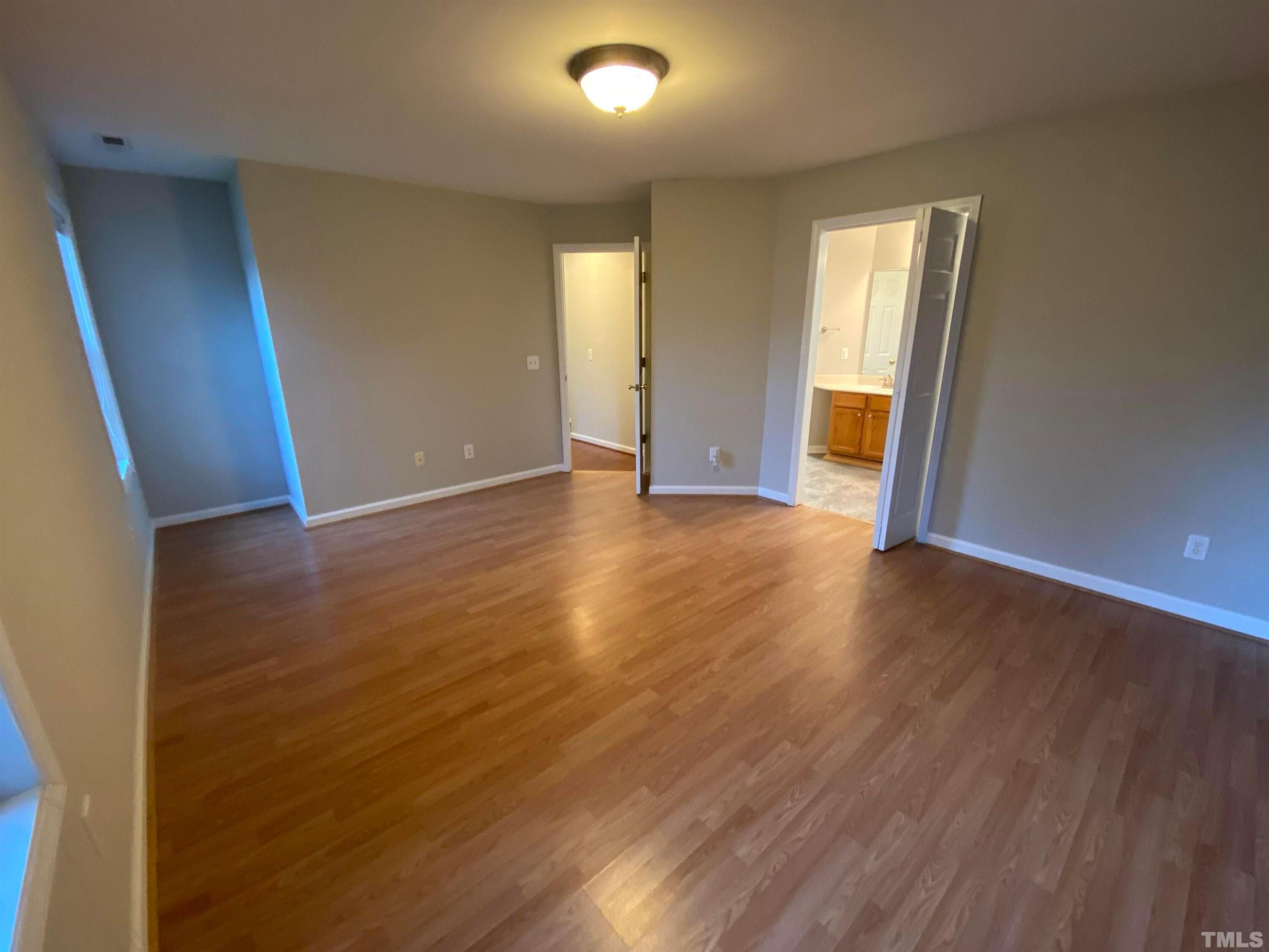 2413 Wellington Ridge Loop, Unit 2413 Cary, NC 27518 - Photo 26 of 30 an empty room with wooden floor and windows
