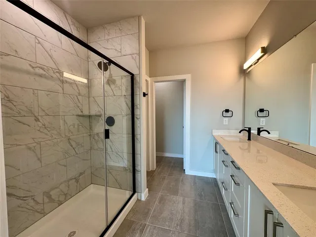 a bathroom with a double vanity sink a mirror and a bathtub
