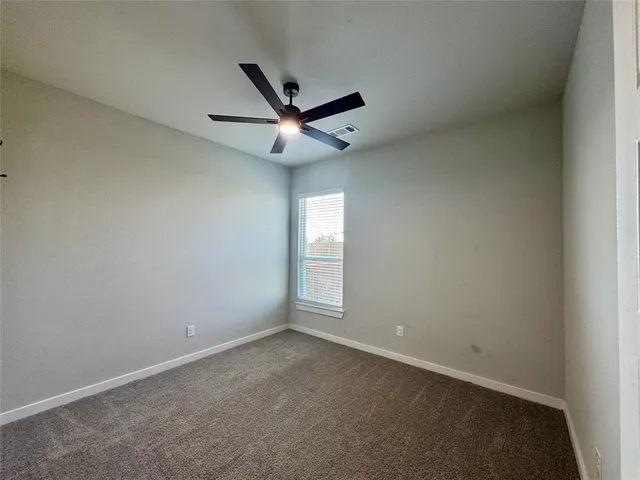 an empty room with a window and a fan