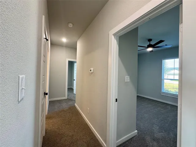 a view of a hallway with closet and wooden floor