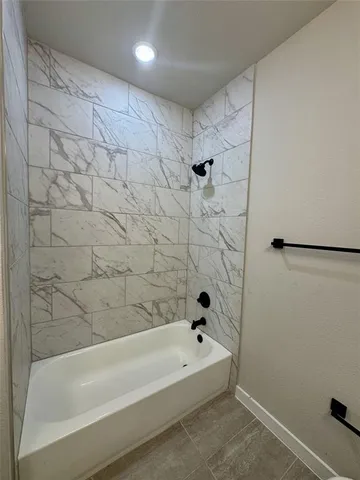 a bathroom with a bathtub and shower