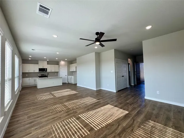 a view of a living room a rug kitchen and a wooden floor