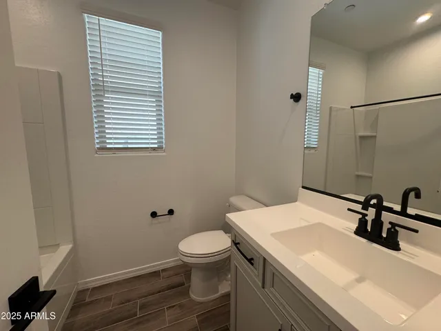 a bathroom with a sink toilet and mirror