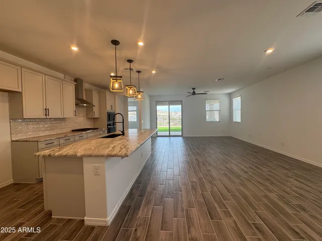 a large kitchen with granite countertop a large counter top and stainless steel appliances