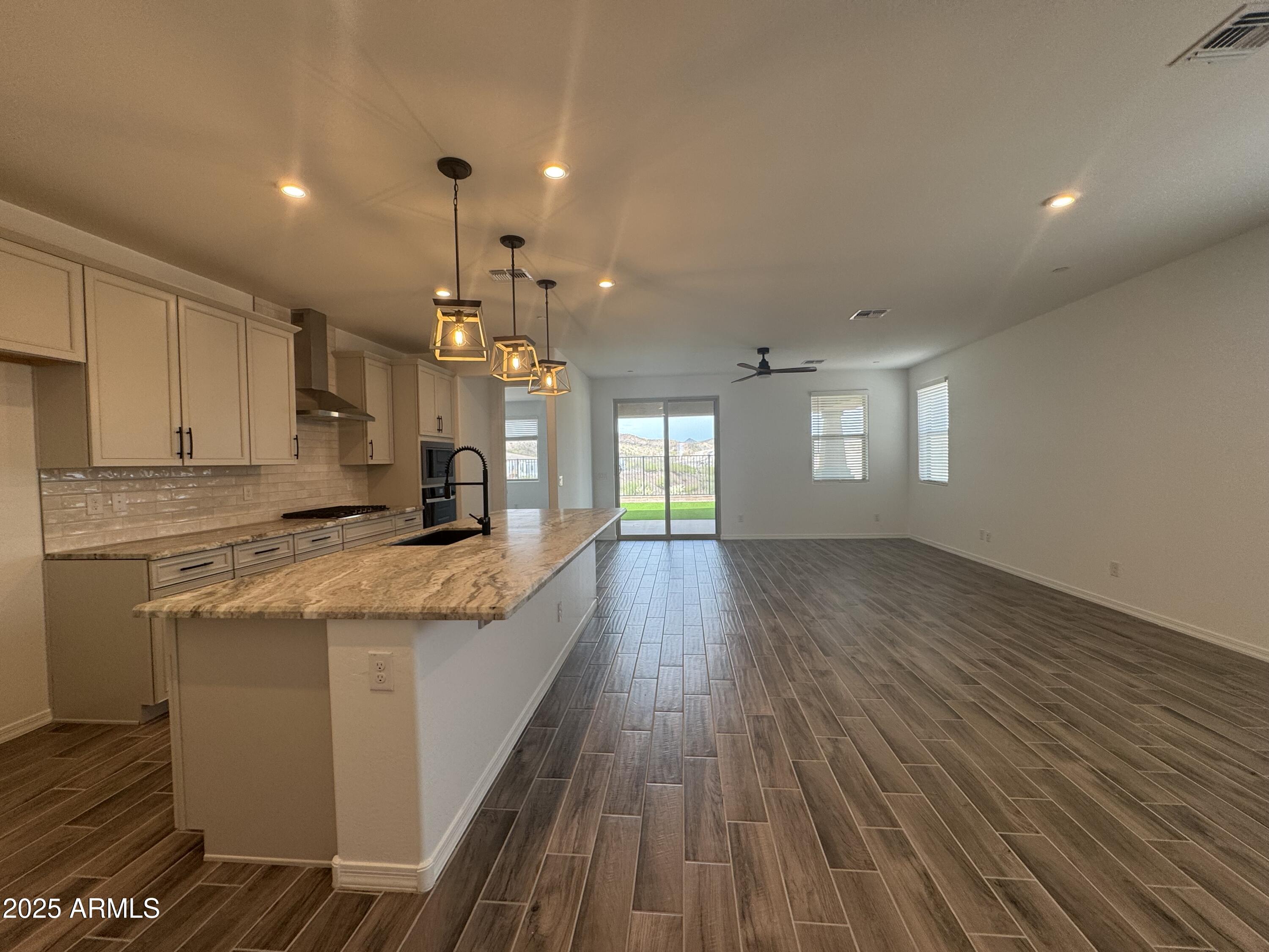 13420 West Eagle Feather Road Peoria, AZ 85383 - Photo 3 of 23 a large kitchen with granite countertop a large counter top and stainless steel appliances
