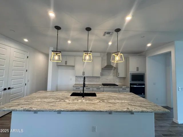 a kitchen with kitchen island sink and refrigerator