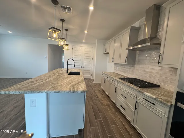 a kitchen with granite countertop cabinets a sink and stainless steel appliances