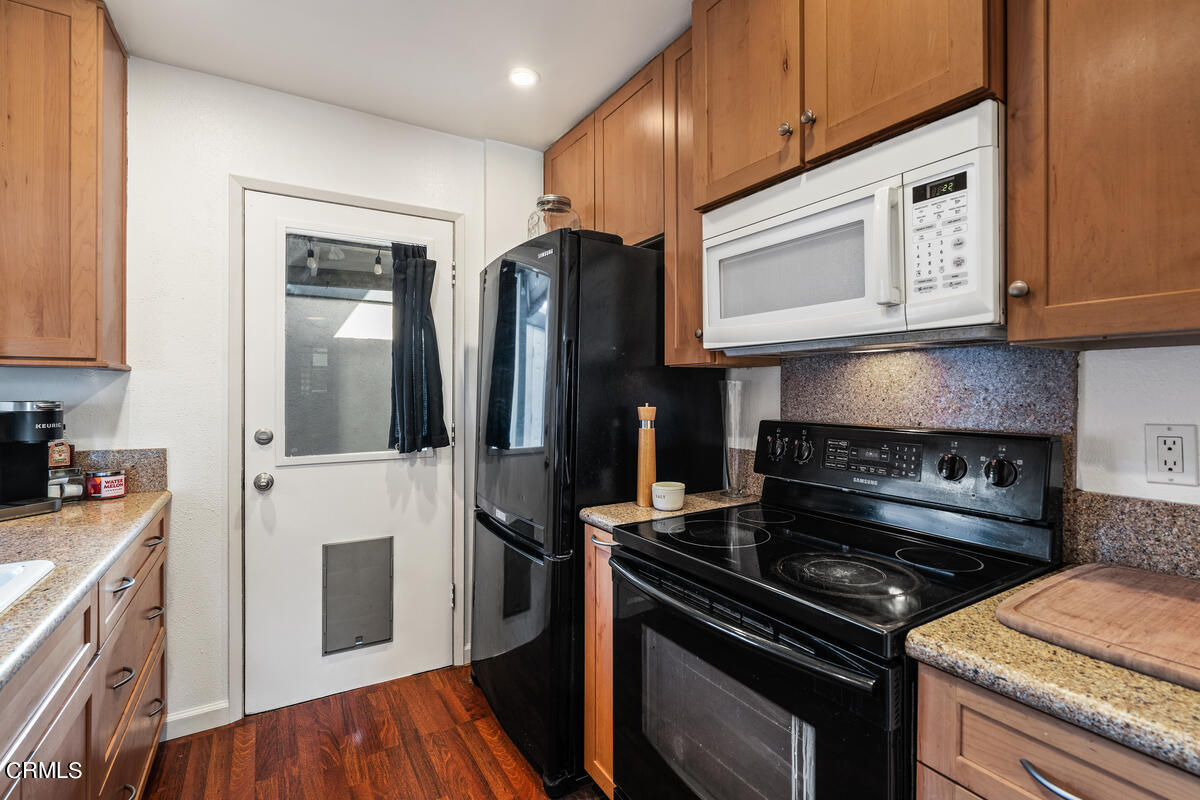 2117 Miramar Walk Oxnard, CA 93035 - Photo 7 of 30 a kitchen with stainless steel appliances granite countertop a stove microwave refrigerator and sink