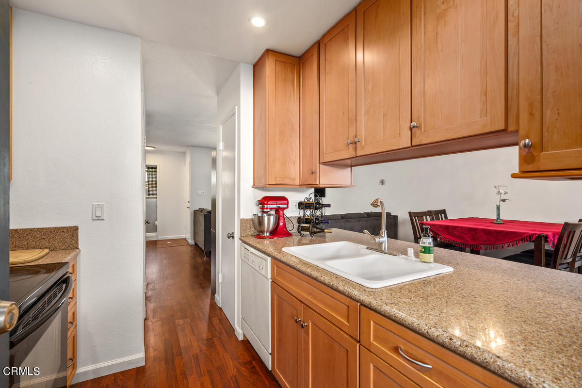 2117 Miramar Walk Oxnard, CA 93035 - Photo 8 of 30 a kitchen with stainless steel appliances granite countertop a sink dishwasher stove refrigerator and cabinets with wooden floor