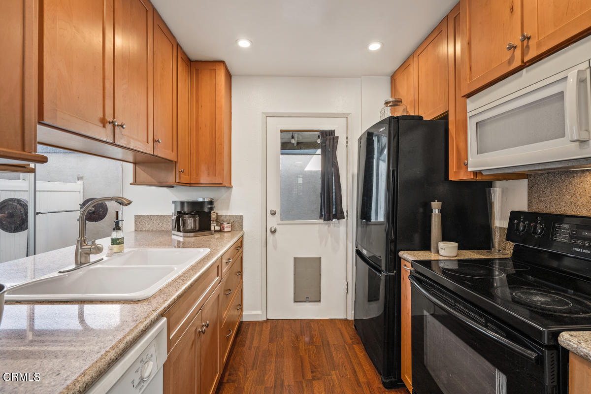 2117 Miramar Walk Oxnard, CA 93035 - Photo 9 of 30 a kitchen with stainless steel appliances granite countertop a sink stove refrigerator and cabinets