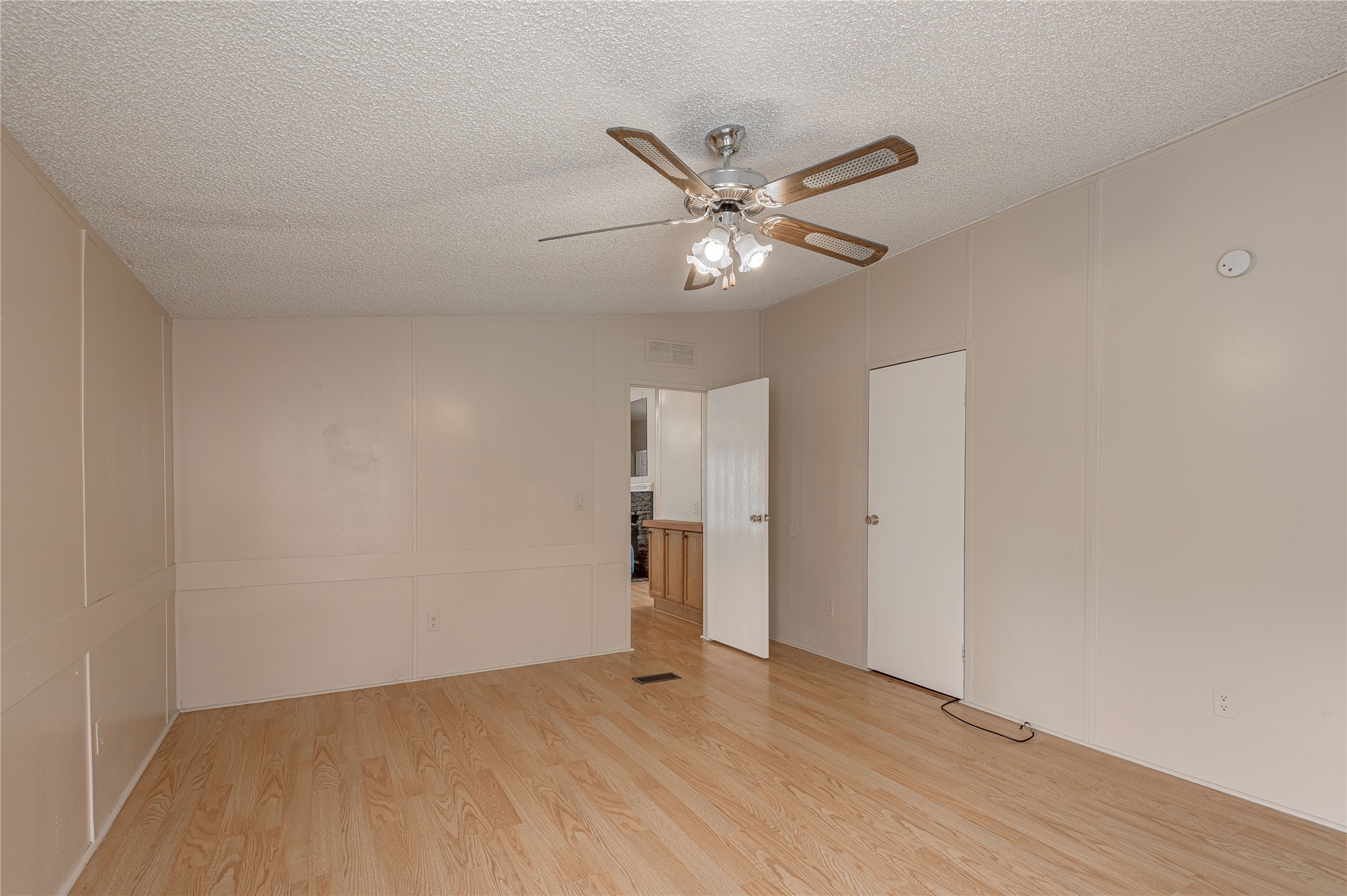 1323 Avenue East Huntsville, TX 77340 - Photo 12 of 28 an empty room with wooden floor and ceiling fan