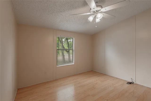an empty room with windows and fan