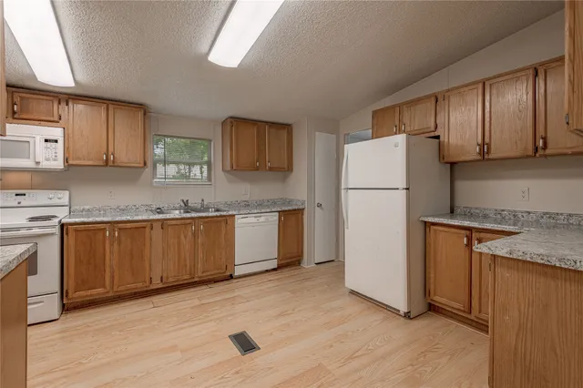 a kitchen with stainless steel appliances granite countertop a refrigerator sink and cabinets