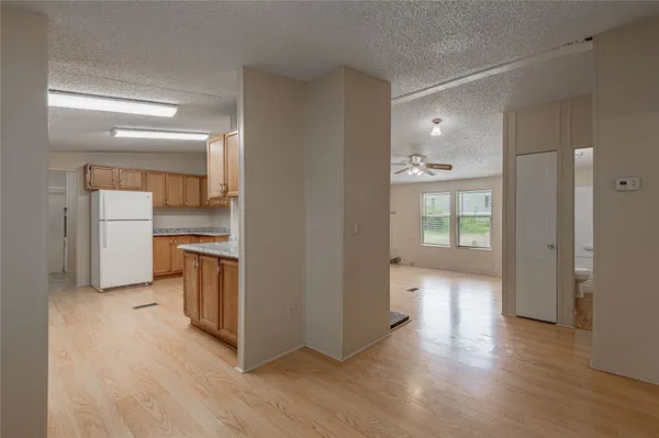 a view of a kitchen with wooden floor and a refrigerator