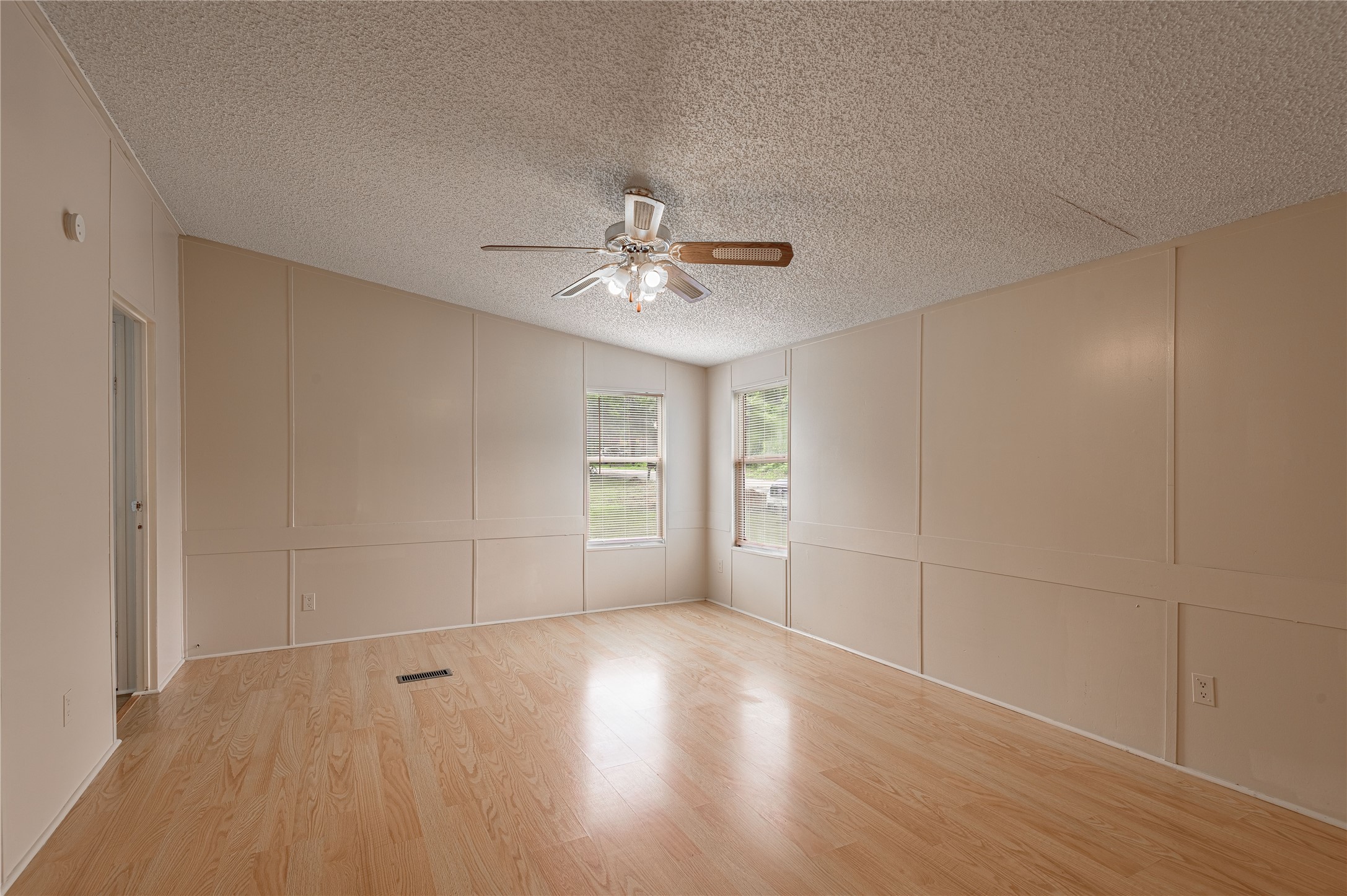 1323 Avenue East Huntsville, TX 77340 - Photo 10 of 28 an empty room with windows and chandelier fan