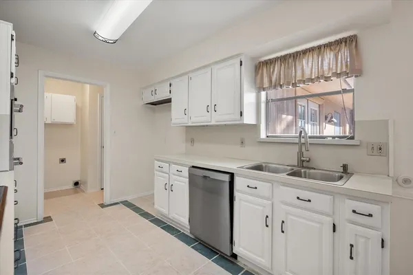 a kitchen with a sink cabinets and a window