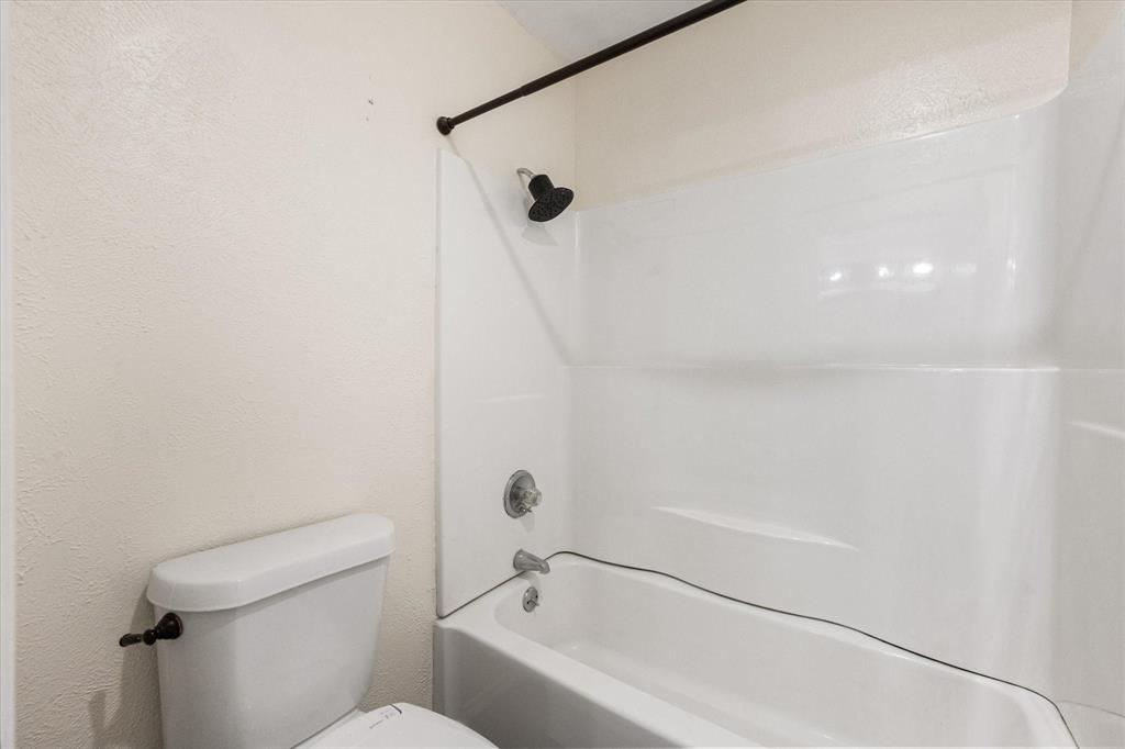 505 Meadow Ridge Drive Cedar Hill, TX 75104 - Photo 19 of 32 a bathroom with a bathtub and a toilet