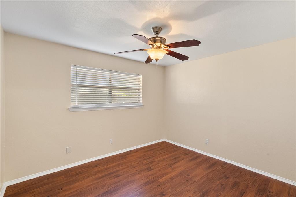 505 Meadow Ridge Drive Cedar Hill, TX 75104 - Photo 20 of 32 a view of an empty room with wooden floor and a fan