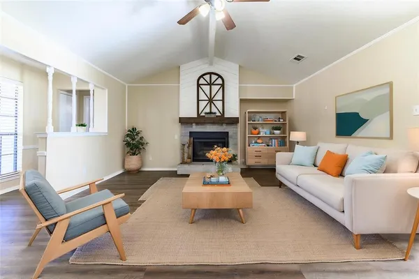 a living room with furniture a fireplace and a chandelier