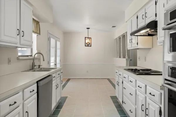 a kitchen with stainless steel appliances a sink stove and cabinets