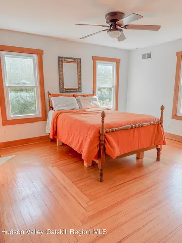 a bedroom with a bed and wooden floor