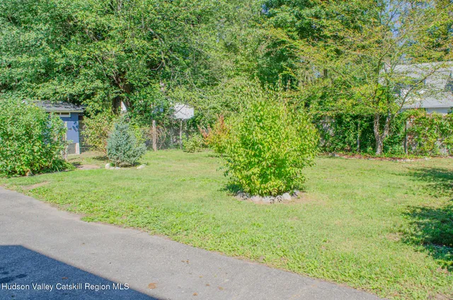 a view of wooden house with a small yard